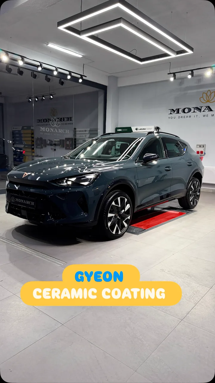 Gri Cupra Formentor, Monarch atölyesinde tavandaki LED ışık çerçevesinin altında; Gyeon seramik kaplama Reels kapağı.